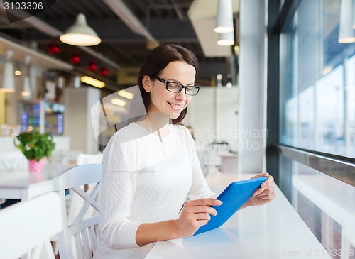 Image of smiling woman with tablet pc at cafe