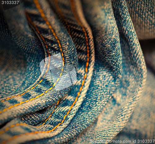 Image of aged Jeans with yellow stitching thread