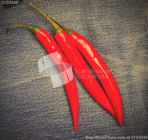 Image of hot chili pepper on jeans background