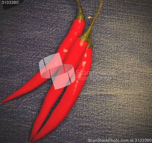 Image of chili pepper on jeans background