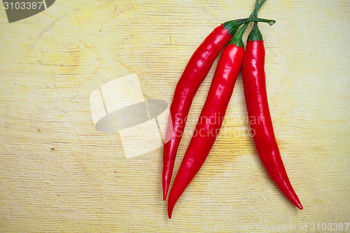 Image of three red hot chili peppers