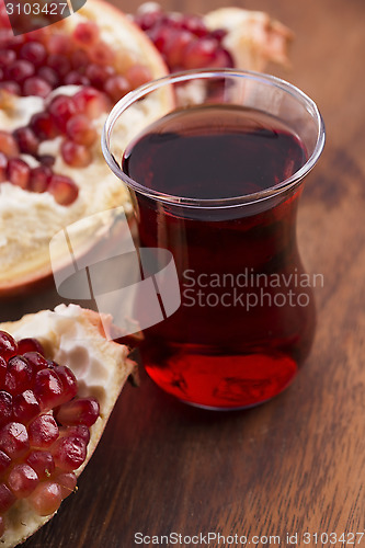 Image of Ripe pomegranates with juice on table