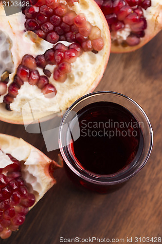 Image of Ripe pomegranates with juice on table