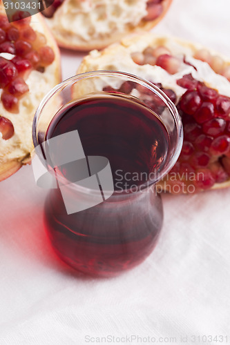 Image of Ripe pomegranates with juice on table