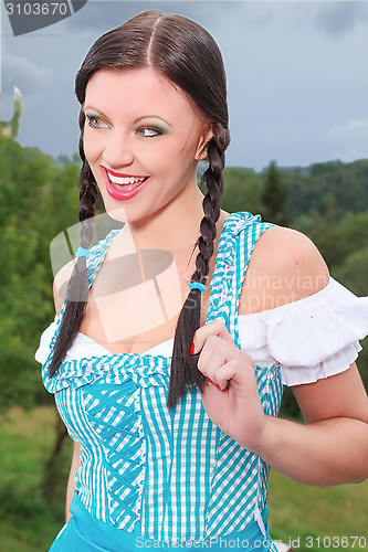 Image of Attractive brunette girl in a dirndl .