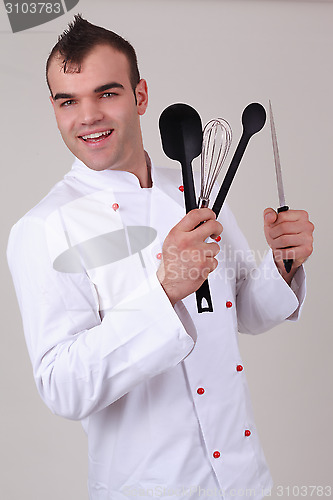 Image of Happy chef holding various kitchen utensils