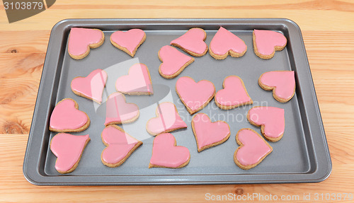 Image of Array of heart-shaped cookies with pink frosting