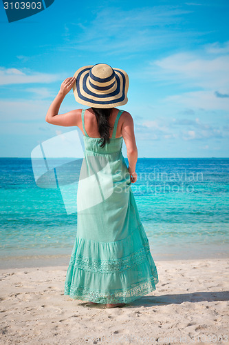 Image of Girl walking along a tropical beach in the Maldives.