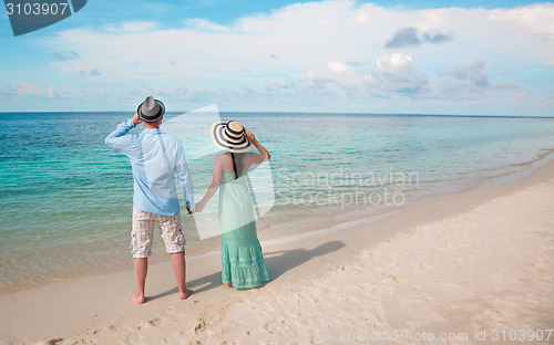 Image of Vacation Couple walking on tropical beach Maldives.