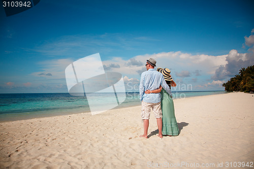 Image of Vacation Couple walking on tropical beach Maldives.