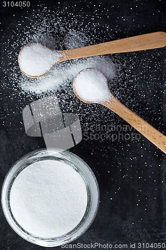Image of sugar in wooden spoons and glass jar 