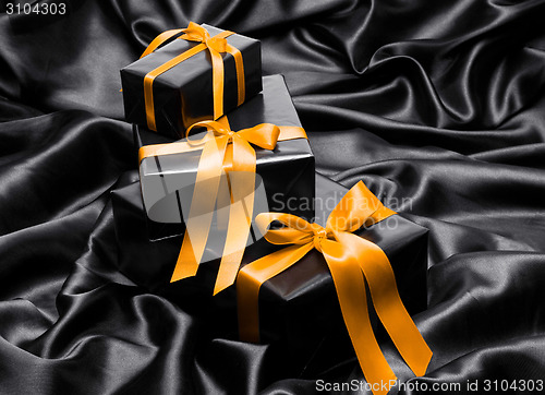 Image of Black gift boxe with yellow satin ribbons and bow