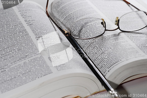 Image of open book with glasses and pencil