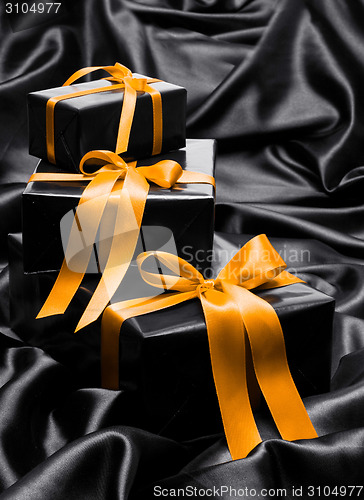 Image of Black gift boxe with yellow satin ribbons and bows