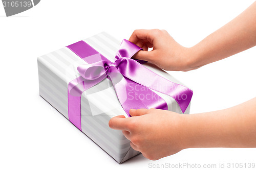 Image of hand holding ribbon and open gift box