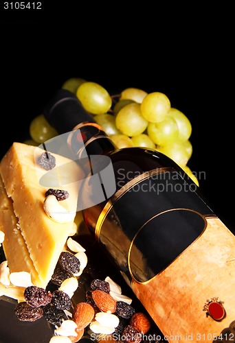 Image of red wine bottle with grape and cheese