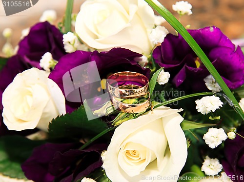 Image of wedding rings and roses arrangements