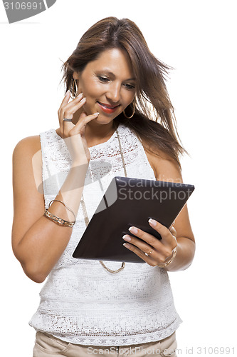 Image of Woman chatting on a mobile while reading a tablet