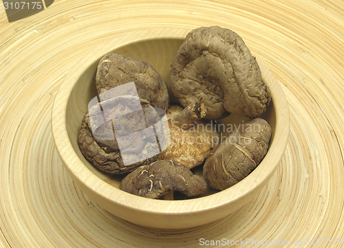 Image of Wooden bowl with shiitake on bamboo plate