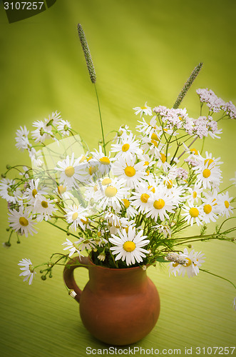 Image of Bouquet of wild flowers in a clay pot, close-up  