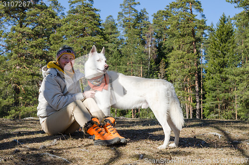 Image of The woman with a white dog in a wood