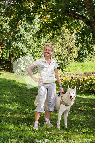 Image of Woman with a dog on a walk in the park