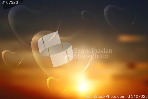 Image of Shiny hearts on sunset sky background