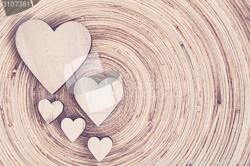 Image of valentine's wooden hearts on a wooden background in retro color