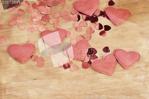 Image of valentine's fabric and confetti hearts on a wooden retro design background