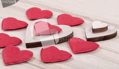 Image of valentine's fabric and wooden hearts on a wooden background