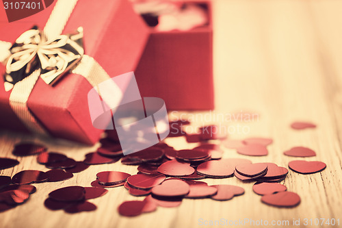 Image of Red hearts confetti on wooden background in retro color