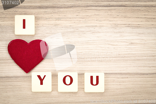 Image of valentine's hearts on a wooden background and tex i love you