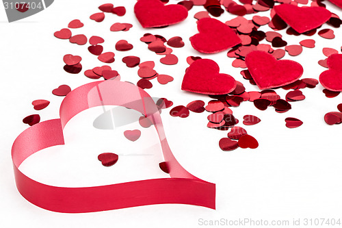 Image of Red hearts confetti and fabric heart on white background