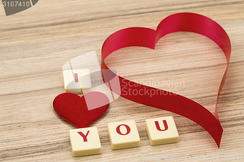 Image of valentine's paper hearts on a wooden background and tex i love you