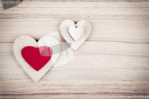 Image of valentine's wooden hearts on a wooden background