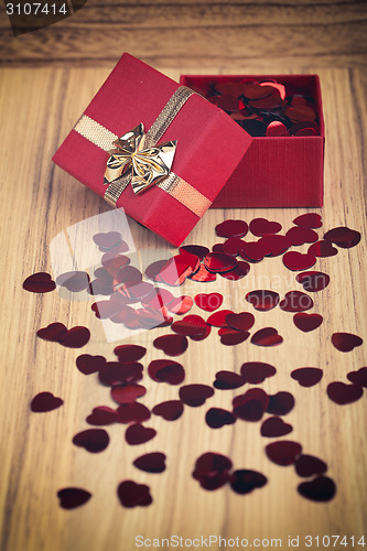 Image of Red hearts confetti on wooden background in retro color