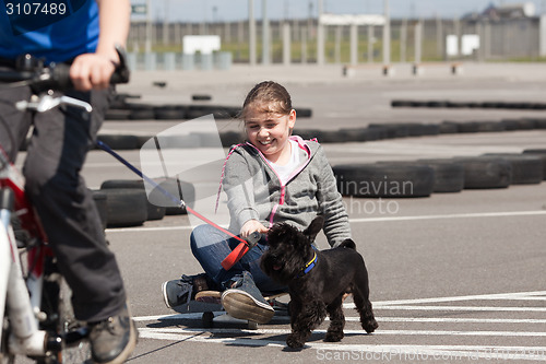 Image of Skateboarder and cyclist with their dog 