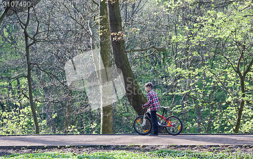 Image of Young boy with bike in park