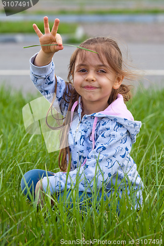 Image of Little girl with pile in hand