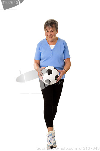 Image of Senior woman walking with football