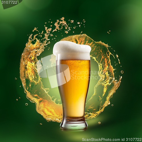 Image of Beer in glass with splash on green background