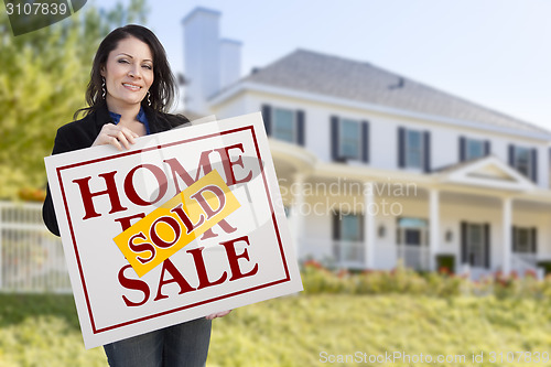 Image of Woman Holding Sold Home Sale Sign in Front of House