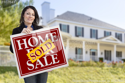 Image of Woman Holding Sold Home Sale Sign in Front of House