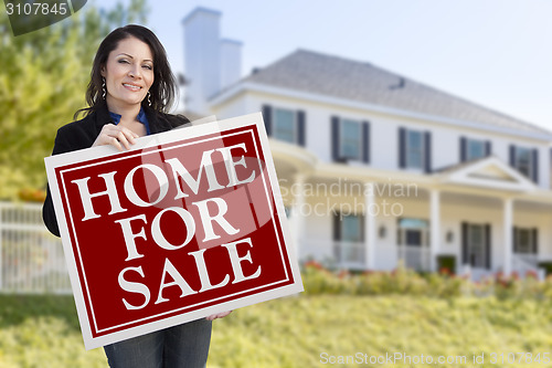 Image of Woman Holding Home For Sale Sign in Front of House