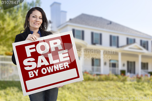 Image of Female Holding Sale By Owner Sign In Front of House