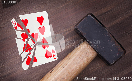 Image of Hammer with a broken card, nine of hearts