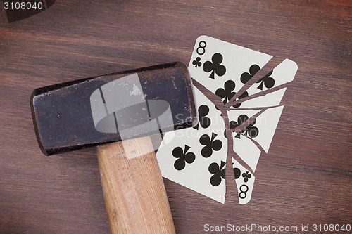 Image of Hammer with a broken card, eight of clubs