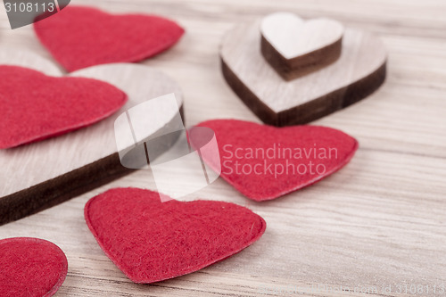 Image of valentine's fabric and wooden hearts on a wooden background