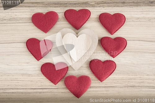 Image of valentine's fabric and wooden hearts on a wooden background