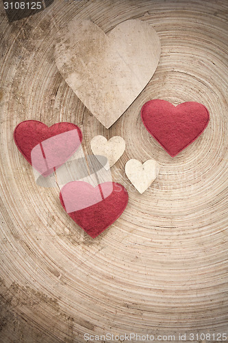 Image of valentine's wooden hearts on a retro background